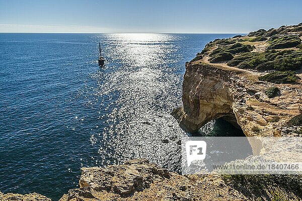 Segelboot auf dem Atlantik  Klippen und Bogen an der Küste der Algarve  Südportugal