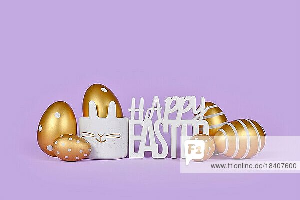 Goldene Ostereier und Text Frohe Ostern auf violettem Hintergrund