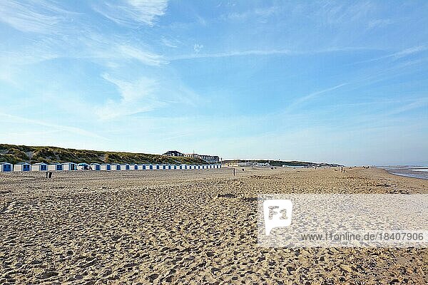 Blick auf den Strandabschnitt Paal 20 mit Strandhütten in der Ferne auf der Insel Texel in den Niederlanden an einem Sommertag mit blauem Himmel
