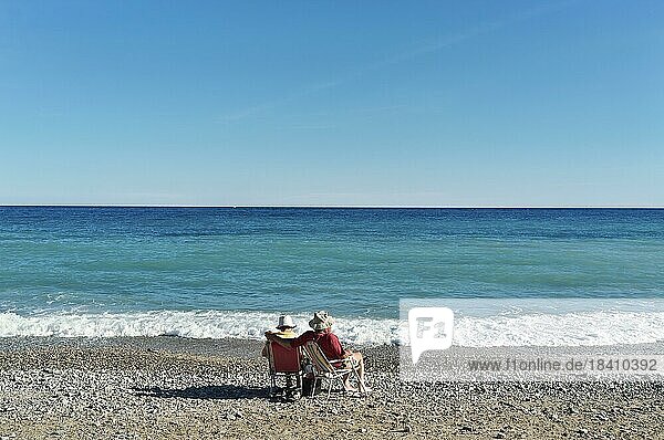 Älteres Paar mit Sonnenhüten auf Campingstühlen am Strand  schaut auf das türkisblaue Mittelmeer Saint Maxime  Var  Frankreich  Europa