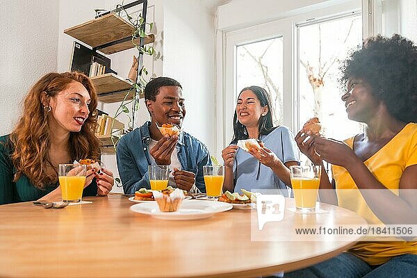 Freunde bei einem Frühstück mit Orangensaft und Muffins zu Hause  gesunder Lebensstil mit Spaß am Morgen