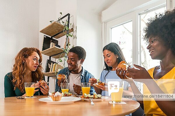 Freunde bei einem Frühstück mit Orangensaft und Muffins zu Hause  entspannt bei heimischen Speisen und Getränken