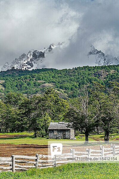 Mit Schindeln gedecktes Holzhaus vor schneebedeckten Bergen  Villa Cerro Castillo  Cerro Castillo-Nationalpark  Aysen  Patagonien  Chile  Südamerika