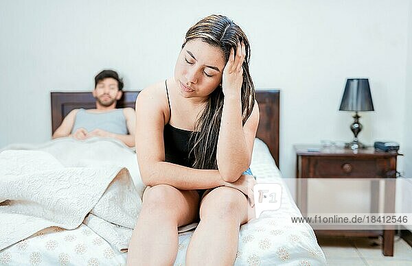 Frau auf dem Rand des Bettes streitet mit ihrem Mann. Aufgeregte Frau  die sich mit ihrem Mann im Bett streitet. Konzept der Paar Probleme im Bett