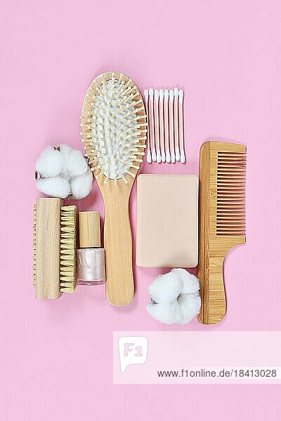 Umweltfreundliche hölzerne Schönheit und Hygieneprodukte wie Kamm und Seife auf rosa Hintergrund angeordnet