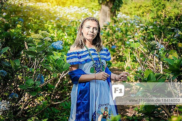 Smiling woman in national folk costume in a field surrounded by flowers. Nicaraguan national folk costume  Young Nicaraguan woman in traditional folk costume in a field of Milflores