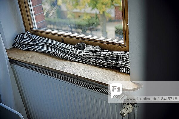 Symbolfoto zum Thema kalte Wohnung. Eine Decke liegt zum Schutz gegen kalte Luft auf der Fensterbank vor einem schlecht isolierten Fenster. Berlin  Berlin  Deutschland  Europa