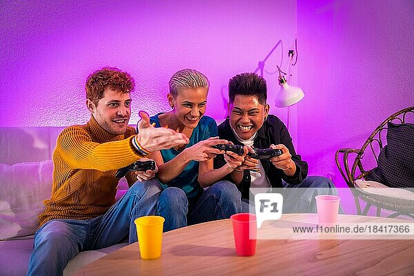 Eine Gruppe junger Freunde spielt zu Hause auf dem Sofa Videospiele  lila angeführt