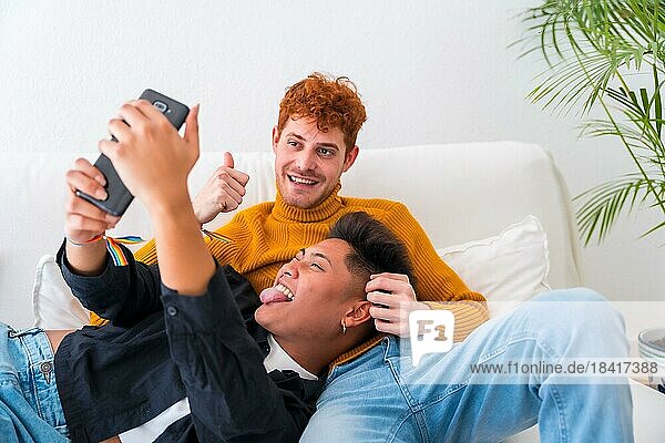Schönes homosexuelles Paar  das drinnen auf dem Sofa romantisch ist  homosexuelles Paar  das ein Selfie macht