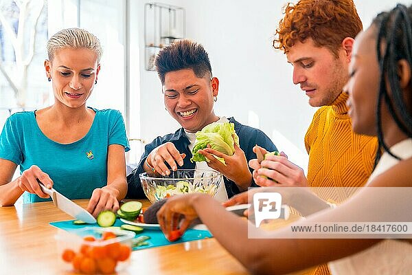 Eine Gruppe von Freunden bereitet ein vegetarisches Essen zu. Den Salat zubereiten und Spaß in der Küche haben