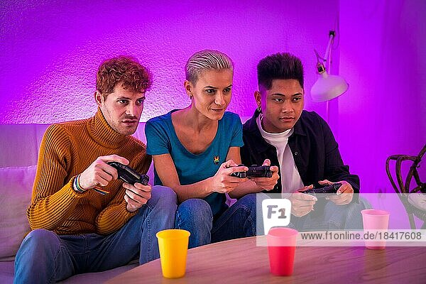 Eine Gruppe junger Freunde spielt gemeinsam Videospiele auf dem Sofa zu Hause