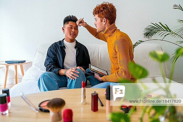 Schöne Homosexuell Paar setzen auf Make up und Spaß haben  romantisch auf dem Sofa  lgbt Konzept