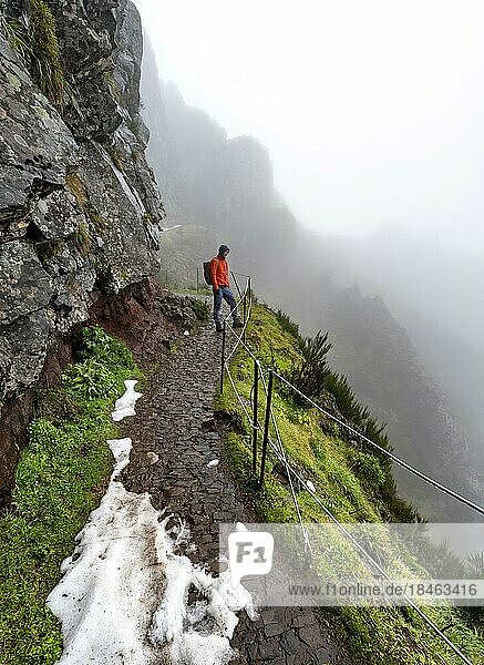 Wanderer im Nebel  Pico Arieiro zum Pico Ruivo Wanderung  schmaler ausgesetzter Wanderweg an Felsenklippe  Zentralgebirge Madeiras  Madeira  Portugal  Europa