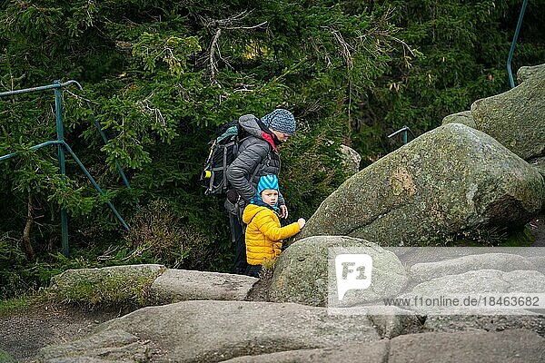 Eine Mutter und ihr kleiner Sohn gehen bei nassem Herbstwetter auf einen Bergpfad. Polnische Berge  Polen  Europa