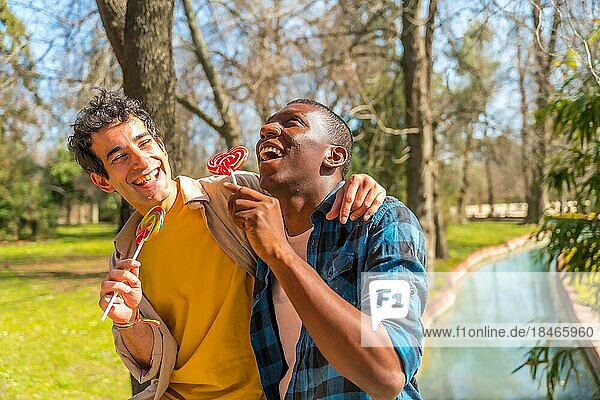 Ein paar multiethnische Männer essen einen Lutscher  lgbt Konzept  haben Spaß und lächeln