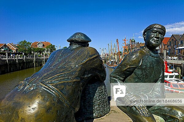 Zwei Bronzestatuen am Hafenkopf von Neuharlingersiel  Ostfriesland  Landkreis Wittmund  Deutschland  Europa