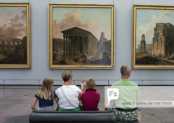 Ein Mann  eine Frau und zwei Kinder  mit dem Rücken zum Fotografen  betrachten ein Gemälde an einer Wand im Louvre  Paris  Frankreich  Europa