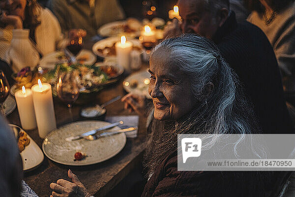 Smiling senior woman looking away during dinner party