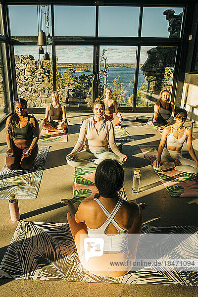 Weiblicher Yogatrainer unterrichtet Schüler während eines Kurses im Retreat Center