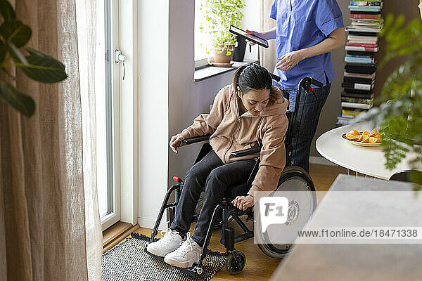 Frau mit Querschnittslähmung passt Rollstuhl zu Hause an