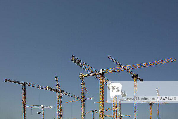 Industrial cranes against clear sky