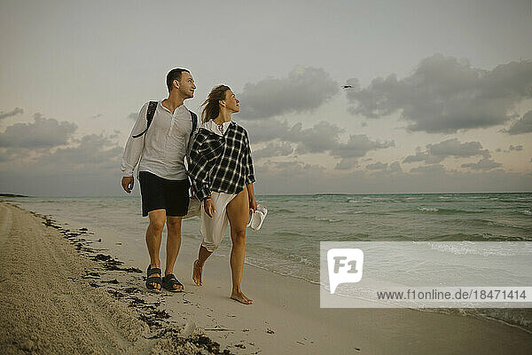 Man and woman walking together near shore at beach