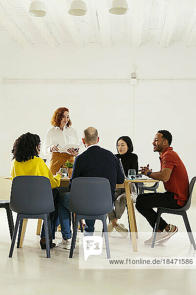 Multiracial colleagues discussing in meeting at office