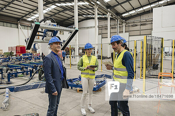 Engineers wearing hardhat standing in robotics factory