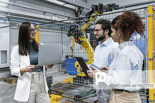 Happy business people having discussion in factory