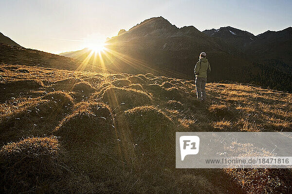 Austria  Tyrol  Female hiker looking toward setting sun