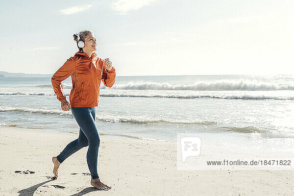 Woman jogging on shore at beach