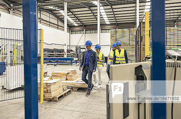 Engineers wearing hardhats walking in factory