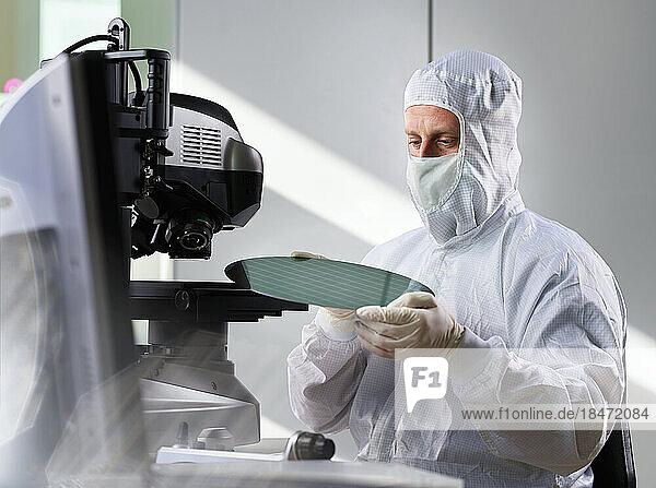 Ingenieur setzt Wafer-Chip auf Mikroskop im Labor
