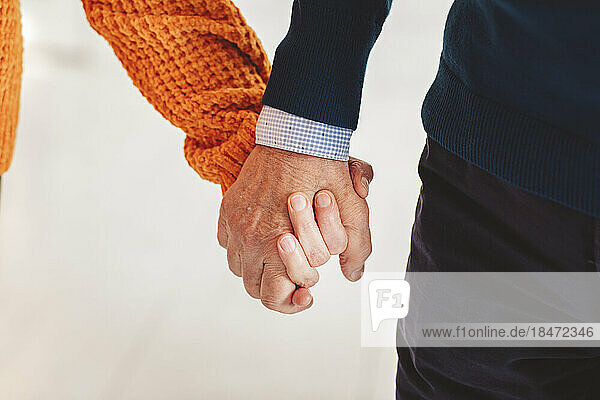 Senior man and woman holding hands