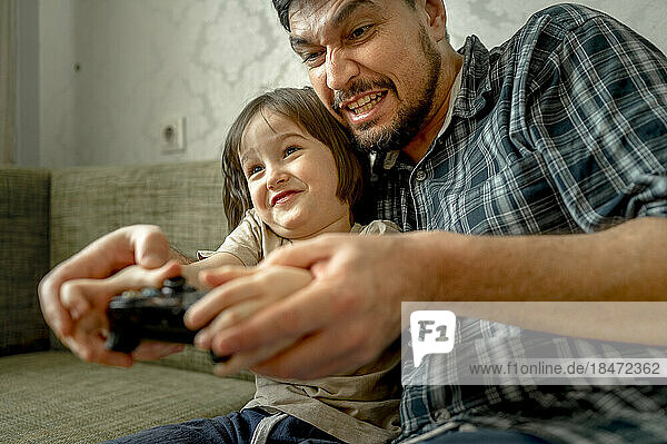 Vater und Sohn spielen zu Hause Videospiele