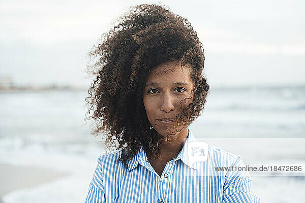 Woman with curly hair in front of sea
