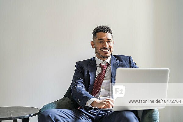 Happy businessman working on laptop