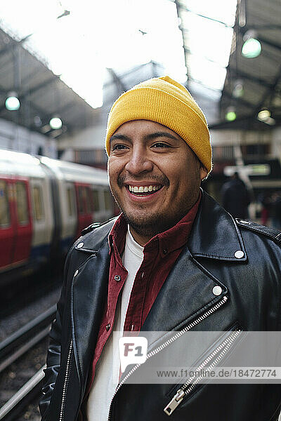 Happy man standing at railroad station platform