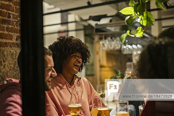 Happy woman with Afro hairstyle enjoying at restaurant