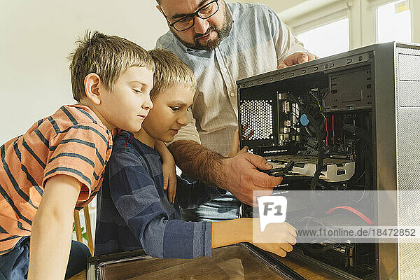 Vater bringt Söhnen bei  zu Hause Computer zu reparieren