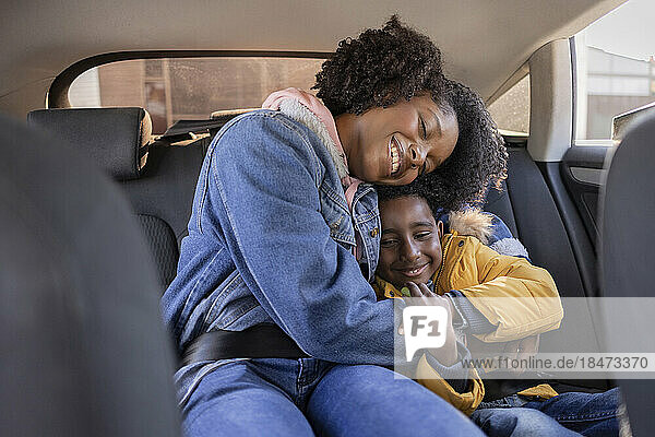 Mother embracing son in car