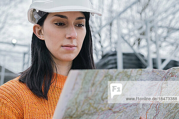 Young woman examining map at site