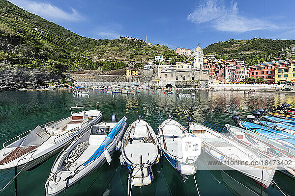 Italy  Liguria  Vernazza  Boats moored at edge of coastal town along Cinque Terre