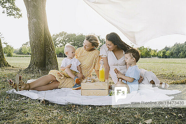 Women spending time with sons in park