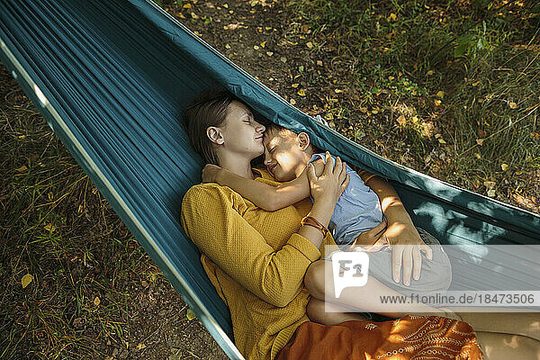 Woman relaxing with son in hammock