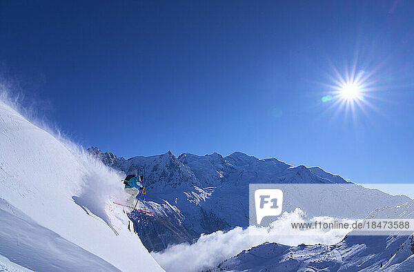 Skifahrer springt auf verschneiten Hang