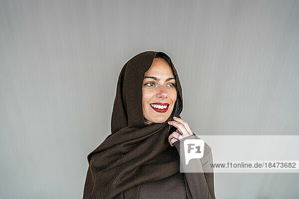 Nachdenkliche Frau mit Hijab vor grauem Hintergrund