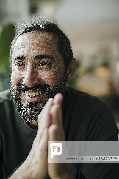 Happy mature man with beard in cafe