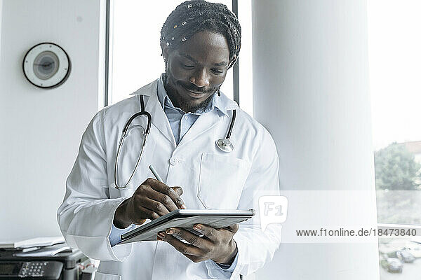Young doctor using tablet PC at clinic
