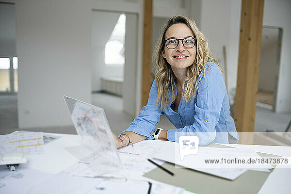 Smiling architect with futuristic tablet PC at desk